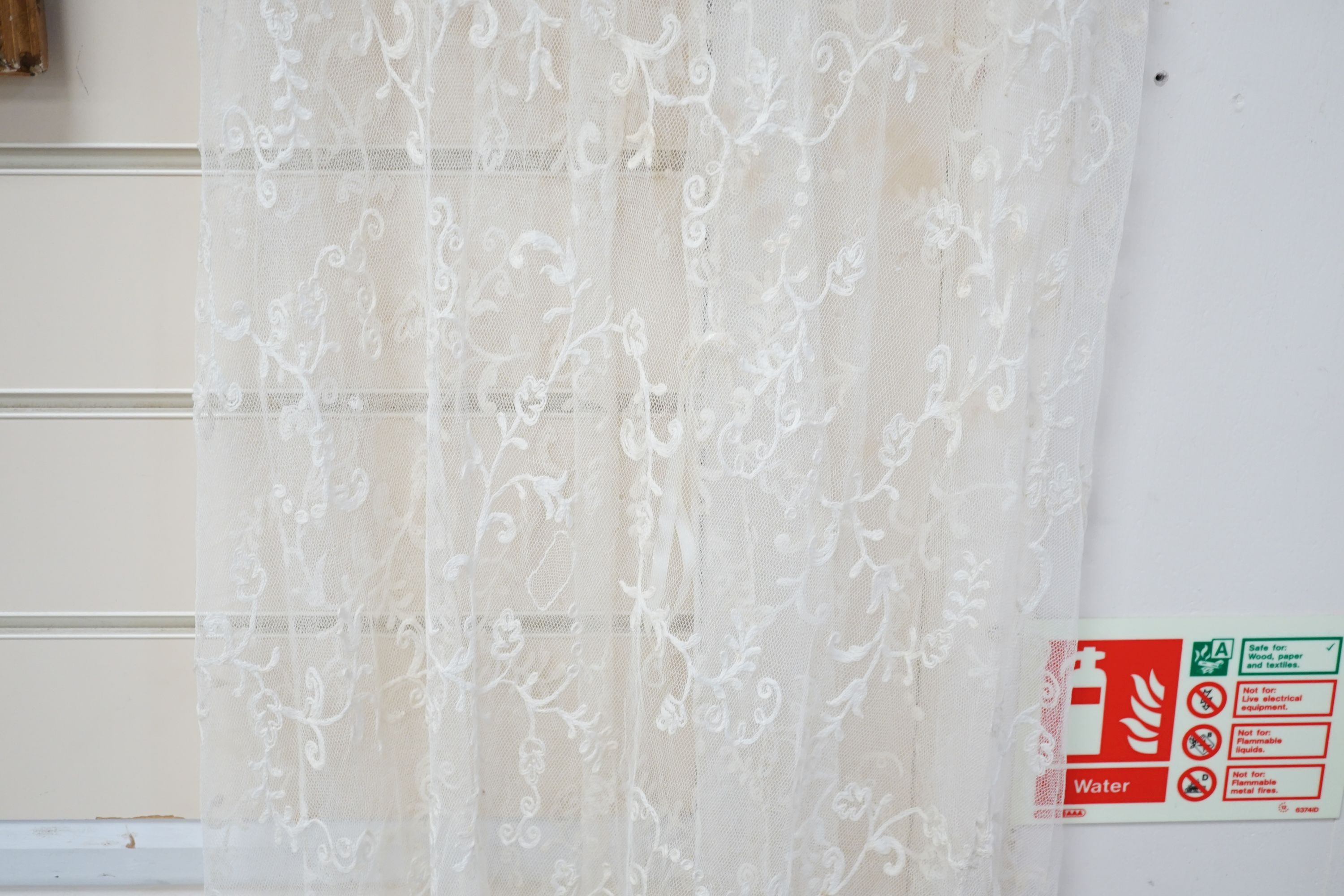 An early 20th century needle run on net lace wedding dress, 155 cms long.